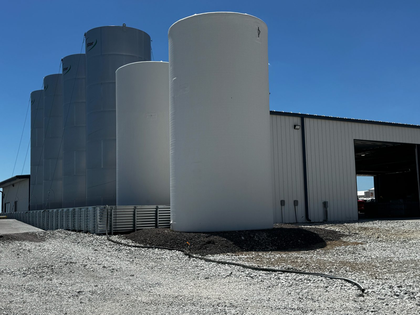 Bulk liquid fertilizer storage tanks and secondary containment outside the new Farm Service Cooperative plant, opened in 2026